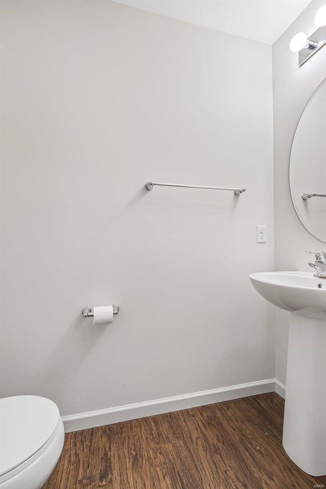 bathroom featuring toilet, baseboards, and wood finished floors