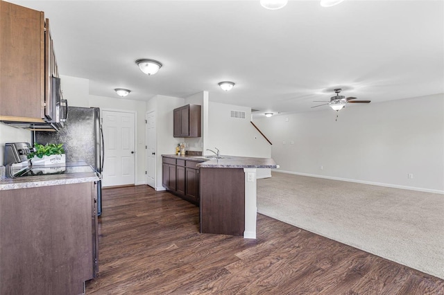 kitchen featuring open floor plan, a peninsula, dark wood-type flooring, and visible vents