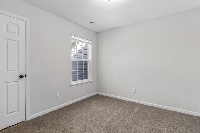 carpeted empty room featuring visible vents and baseboards