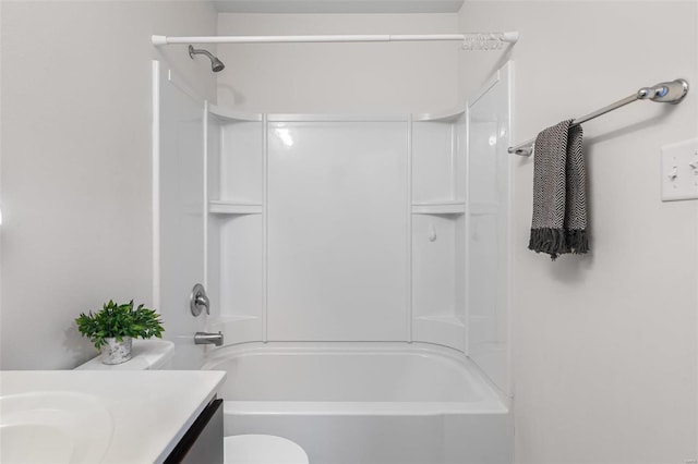 bathroom featuring washtub / shower combination, vanity, and toilet