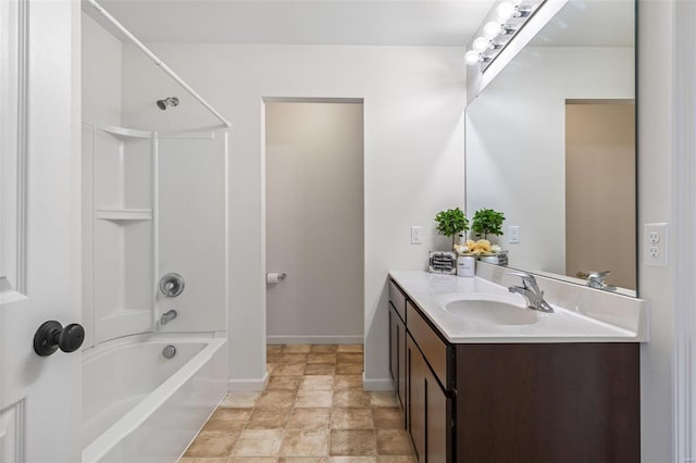 bathroom with stone finish flooring, baseboards, bathing tub / shower combination, and vanity