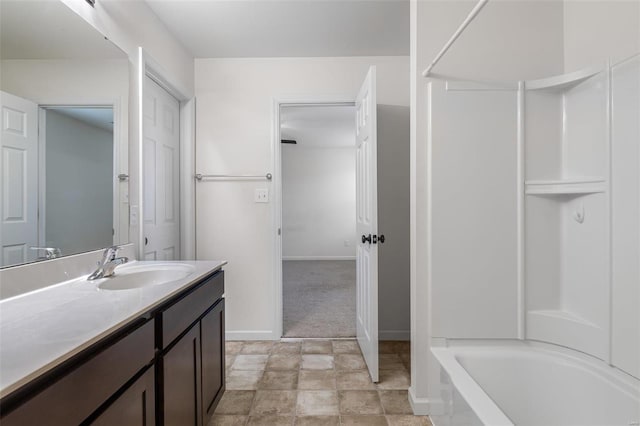 bathroom with baseboards, tub / shower combination, and vanity