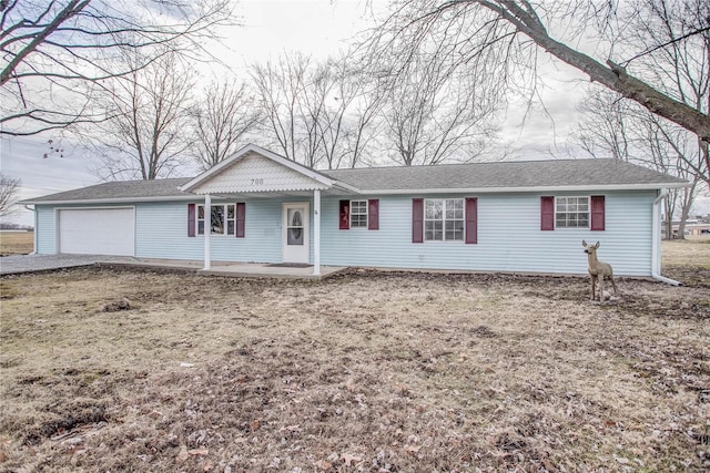 ranch-style home with an attached garage and a shingled roof