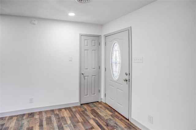 foyer entrance featuring dark wood finished floors and baseboards