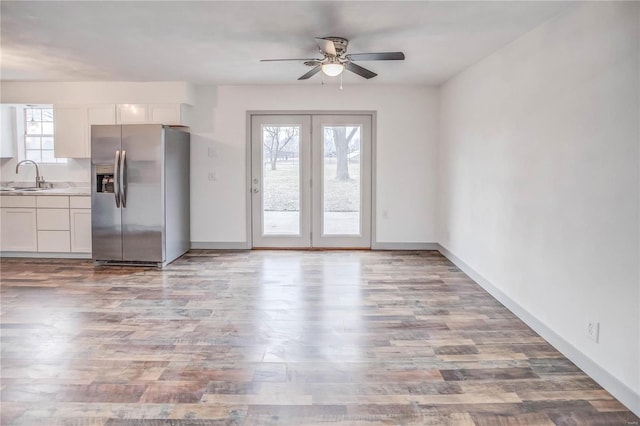 interior space featuring light countertops, light wood-style floors, white cabinetry, a sink, and stainless steel fridge