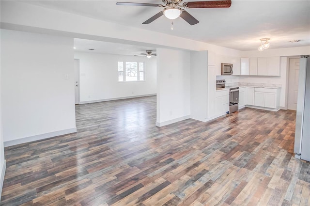 kitchen with appliances with stainless steel finishes, open floor plan, wood finished floors, light countertops, and white cabinetry