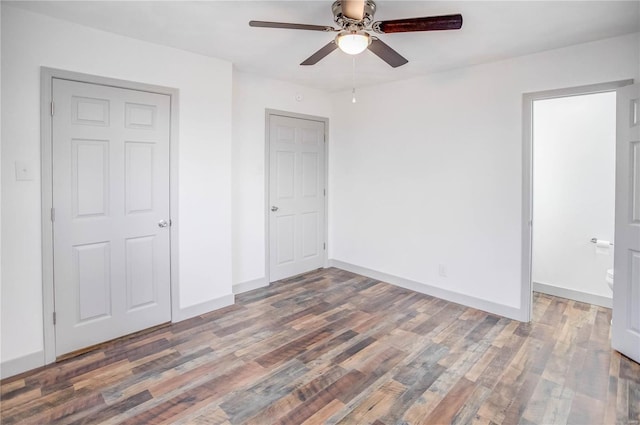 unfurnished bedroom with dark wood-type flooring, baseboards, and a ceiling fan