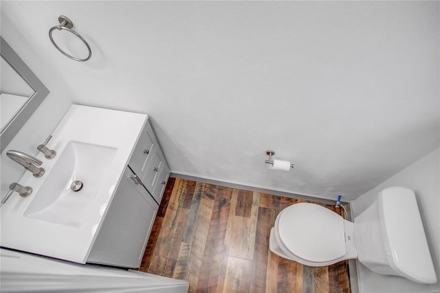 bathroom featuring toilet, wood finished floors, and vanity