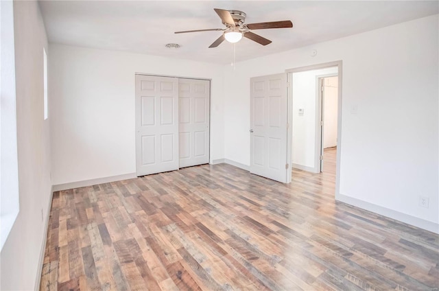 unfurnished bedroom featuring light wood-style flooring, baseboards, and a closet