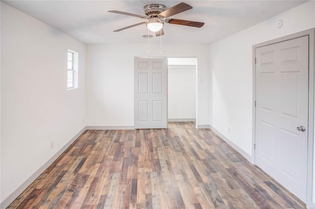 unfurnished bedroom featuring dark wood-style floors, baseboards, and a closet