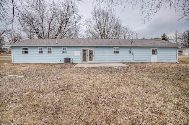 rear view of property featuring central AC unit, a lawn, and a patio