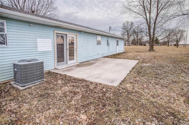 rear view of property featuring a yard, a patio, and central AC unit