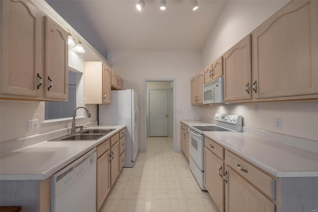 kitchen featuring light floors, white appliances, a sink, and light countertops