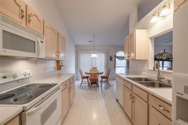 kitchen with white appliances, light countertops, light brown cabinetry, light floors, and a sink