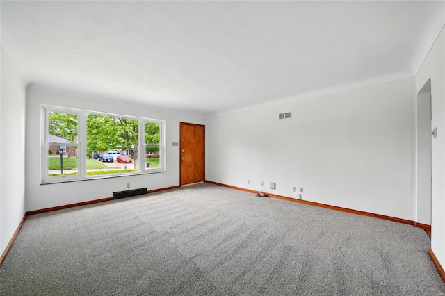spare room with carpet floors, baseboards, and visible vents
