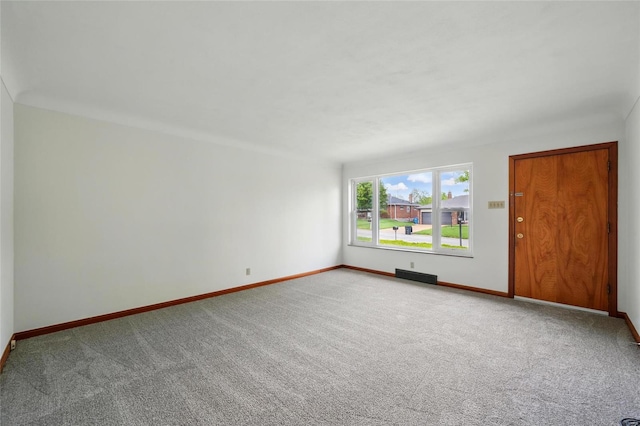 carpeted spare room featuring baseboards and visible vents