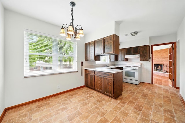 kitchen featuring a sink, baseboards, white range with gas cooktop, an inviting chandelier, and under cabinet range hood