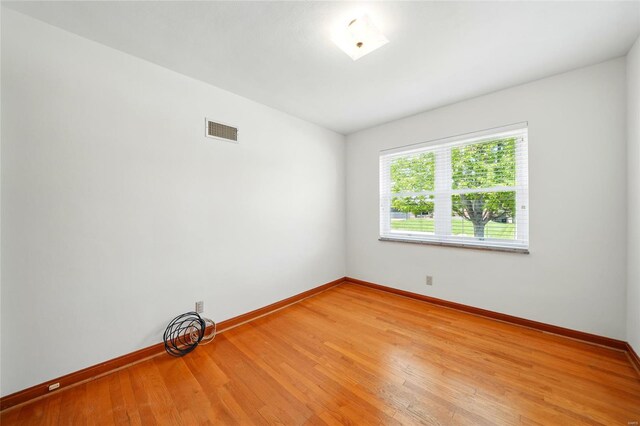 unfurnished room featuring visible vents, light wood-style flooring, and baseboards