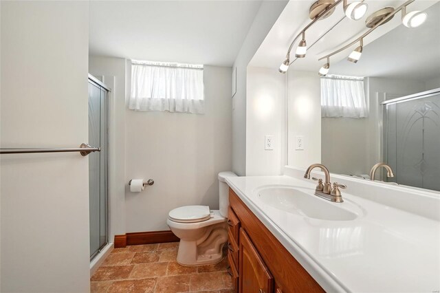 bathroom featuring a healthy amount of sunlight, a stall shower, and toilet