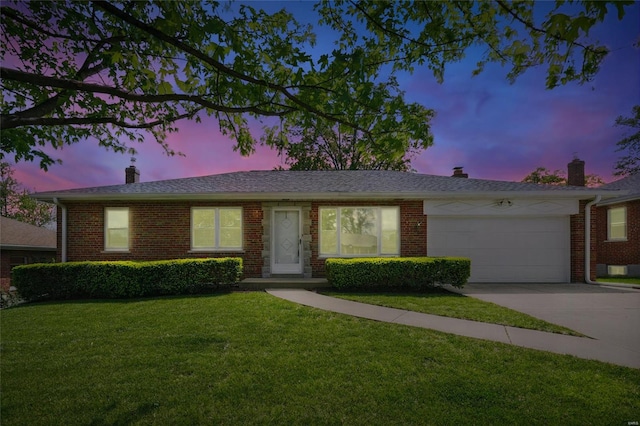 ranch-style home with an attached garage, brick siding, a front yard, a chimney, and concrete driveway