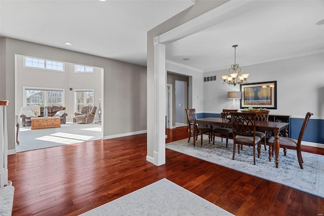 dining space featuring visible vents, baseboards, wood finished floors, and a chandelier