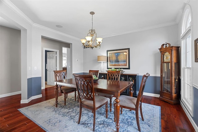 dining space with visible vents, crown molding, baseboards, an inviting chandelier, and wood finished floors