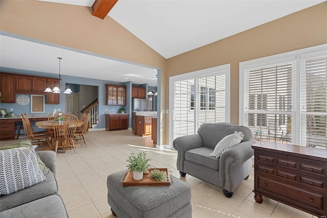 living area with an inviting chandelier, stairway, vaulted ceiling with beams, and light tile patterned flooring