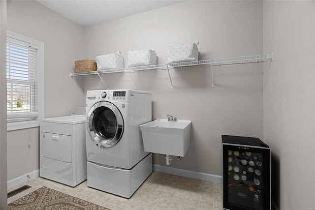 laundry room featuring visible vents, baseboards, washer and clothes dryer, wine cooler, and laundry area