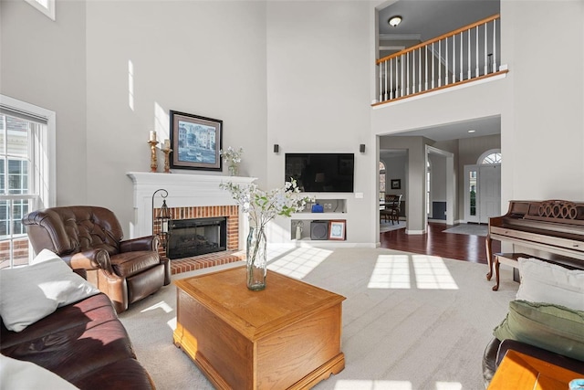 carpeted living room with a brick fireplace and baseboards