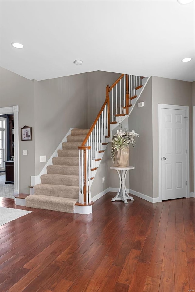 staircase with hardwood / wood-style floors, recessed lighting, and baseboards