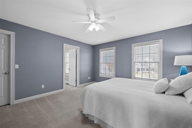 bedroom featuring connected bathroom, baseboards, carpet, and a ceiling fan