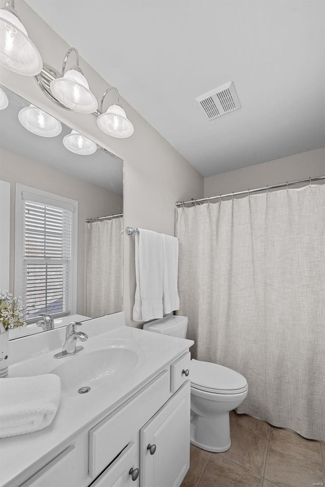 bathroom with tile patterned flooring, visible vents, toilet, and vanity