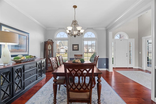 dining room featuring baseboards, an inviting chandelier, dark wood finished floors, and crown molding