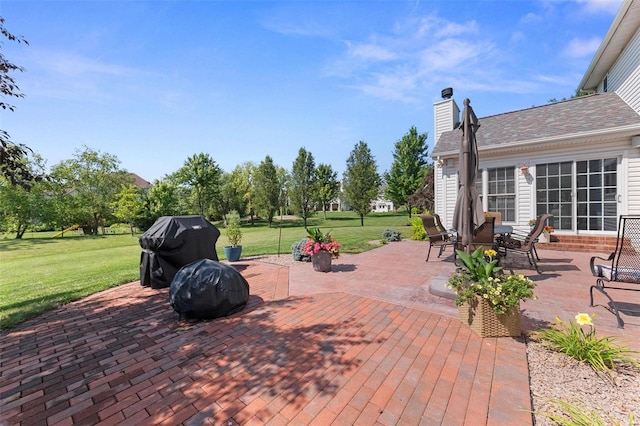 deck with a patio area, a lawn, and grilling area