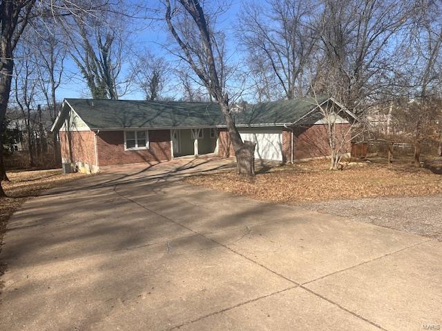 view of front of house with brick siding and concrete driveway