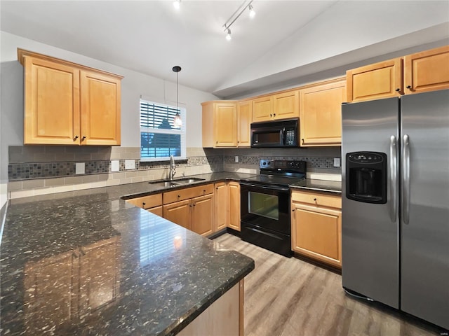 kitchen with lofted ceiling, black appliances, tasteful backsplash, and a sink