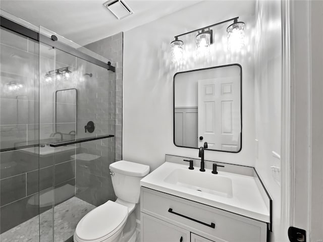 bathroom with toilet, a shower stall, visible vents, and vanity