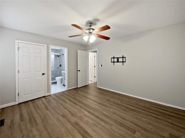 unfurnished bedroom featuring a ceiling fan, wood finished floors, connected bathroom, and baseboards