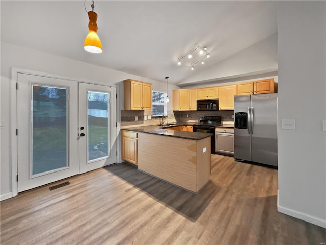 kitchen with dark countertops, light brown cabinetry, a sink, a peninsula, and black appliances