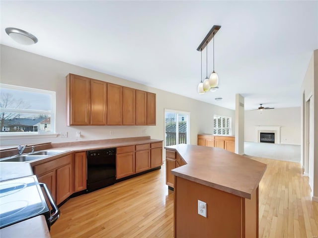 kitchen with dishwasher, a kitchen island, light countertops, a healthy amount of sunlight, and pendant lighting