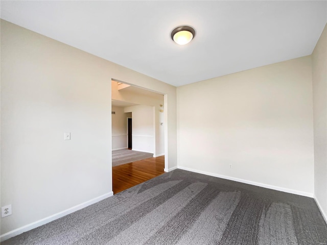 unfurnished room with carpet and baseboards