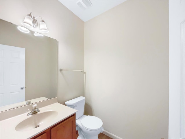 bathroom with toilet, visible vents, and vanity