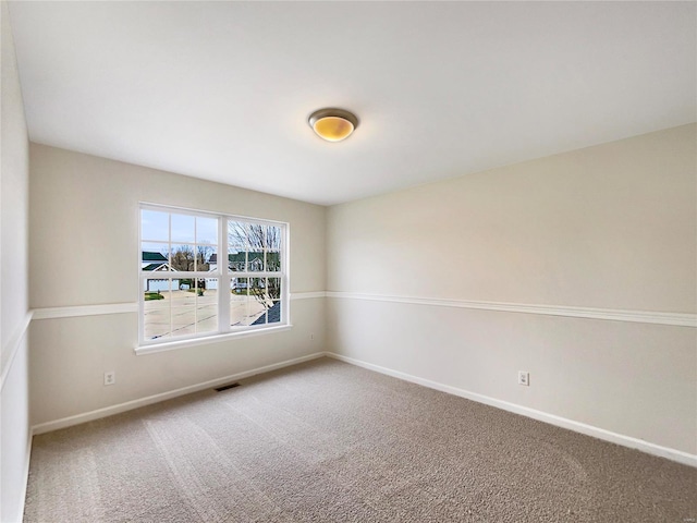 spare room with visible vents, baseboards, and carpet flooring