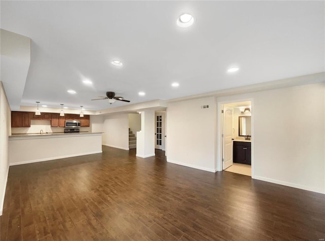 unfurnished living room featuring dark wood-style floors, ceiling fan, stairway, and recessed lighting