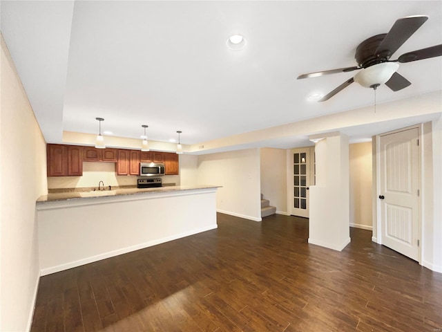 unfurnished living room featuring baseboards, stairway, dark wood-style flooring, a sink, and recessed lighting