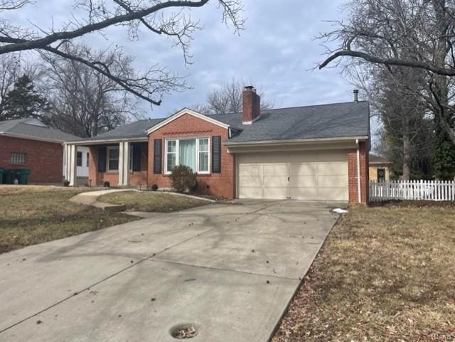 single story home featuring an attached garage, brick siding, fence, driveway, and a chimney