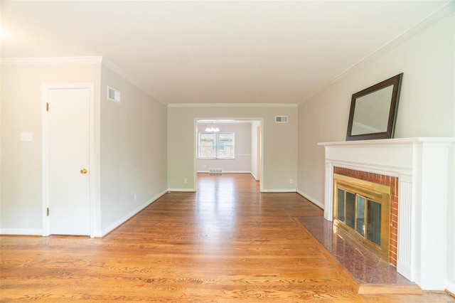 unfurnished living room featuring a brick fireplace, wood finished floors, visible vents, and baseboards