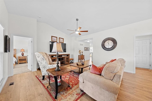 living room with visible vents, light wood finished floors, a ceiling fan, and vaulted ceiling
