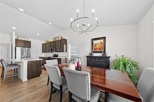 dining room with a chandelier, recessed lighting, light wood-style flooring, and lofted ceiling