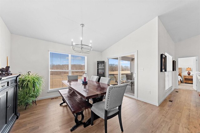 dining room featuring baseboards, high vaulted ceiling, a chandelier, and light wood finished floors